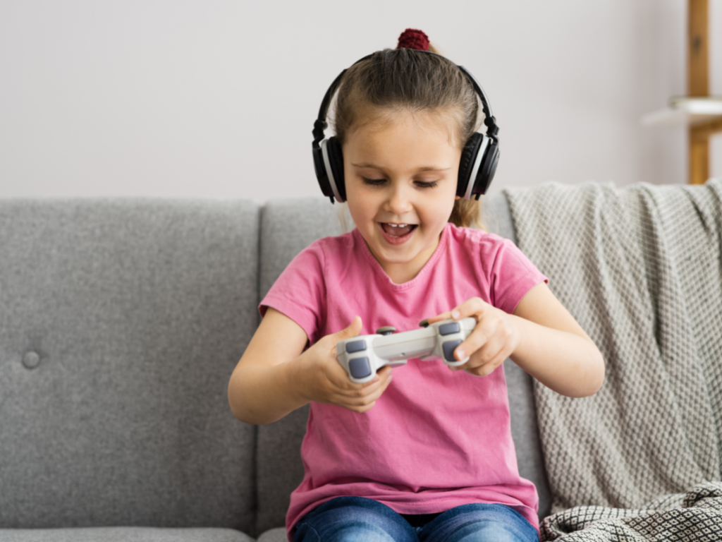 A menina com portátil joga o conceito dos jogos do vício do jogo